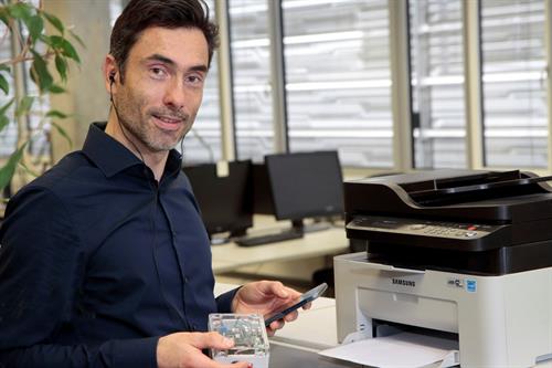 Siegbert Versümer mit Smartphone und Tonaufzeichnungsgerät am Drucker. 